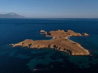 Rocky Island and Boat in Deep Blue Coastal Waters Near Athos, Greece