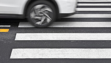 CAR DRIVING OVER PEDESTRIAN CROSSWALK WITH DANGER - Risk of accident as vehicle crosses zebra lines on asphalt street, symbol of traffic hazard, unsafe driving and road safety violation