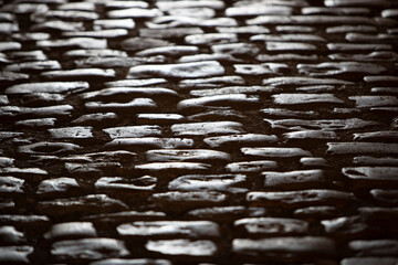 Plan rapproché sur une rue pavée mouillée après la pluie. Une route pavée en briques baignés d'une lumière chaleureuse. Architecture urbaine classique, décor historique. Concept de voyage, tourisme.