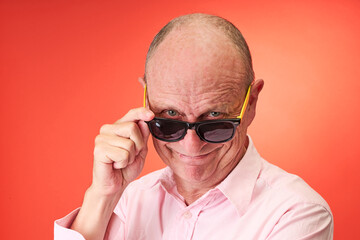 Closeup portrait of a elderly man in studio wearing sunglasses