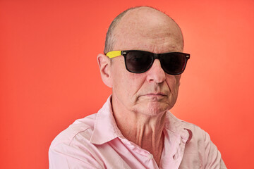 Closeup portrait of a elderly man in studio wearing sunglasses