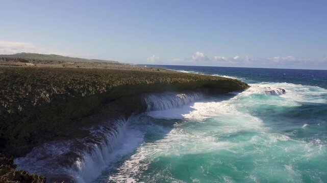 Shete Boka National Park in Curacao. Waves pound against coral rock formations and saltwater splashes high into the air. Cliff-like sea coves.