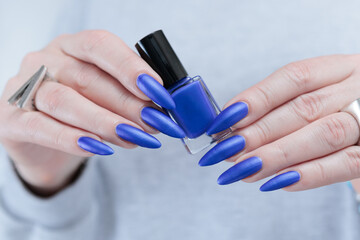 Woman's beautiful hand with long nails and blue manicure