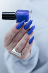 Woman's beautiful hand with long nails and blue manicure