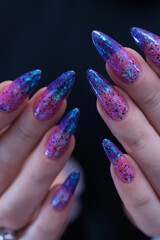 Female hand with long nails and blue and purple thermo french nail polish
