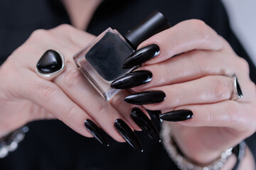 Female hands with long nails and black nail polish
