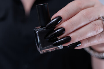 Female hands with long nails and black nail polish