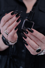 Female hands with long nails and black nail polish