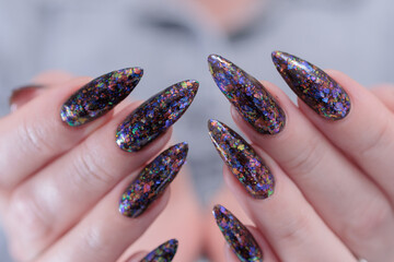 Female hands with long nails and black nail polish
