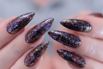 Female hands with long nails and black nail polish