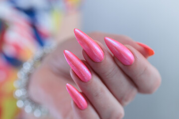 beautiful female hands with long nails and bright neon pink red nail polish