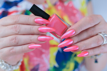 beautiful female hands with long nails and bright neon pink red nail polish