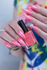 beautiful female hands with long nails and bright neon pink red nail polish
