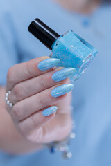 Woman's beautiful hand with long nails and light baby blue manicure