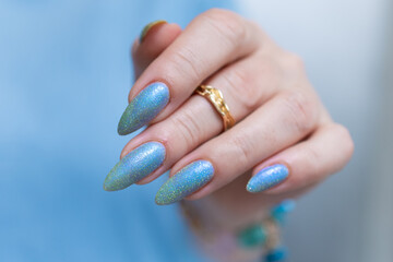 Woman's beautiful hand with long nails and light baby blue manicure	
