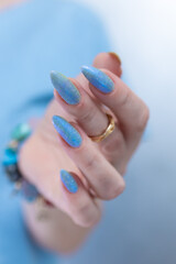 Woman's beautiful hand with long nails and bright blue manicure