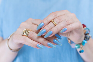 Fototapeta premium beautiful hand with long nails and light baby blue manicure 