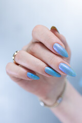 Woman's beautiful hand with long nails and bright blue manicure