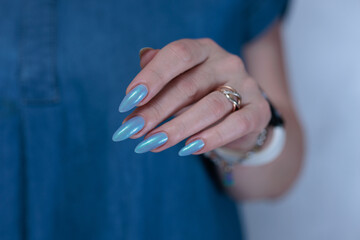 beautiful hand with long nails and light baby blue manicure	
