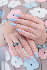 Woman's beautiful hand with long nails and light baby blue manicure	