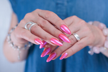 beautiful female hands with long nails and bright neon pink red nail polish