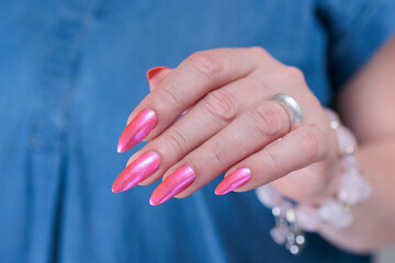 beautiful female hands with long nails and bright neon pink red nail polish