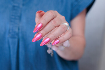 beautiful female hands with long nails and bright neon pink red nail polish