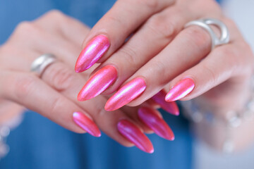beautiful female hands with long nails and bright neon pink red nail polish