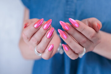 beautiful female hands with long nails and bright neon pink red nail polish