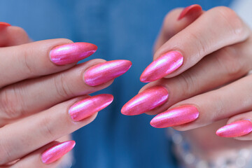beautiful female hands with long nails and bright neon pink red nail polish