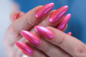 beautiful female hands with long nails and bright neon pink red nail polish