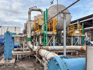 Complex industrial multi effect desalination landscape of pipes, tanks, and metal structures, with...