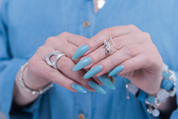 Woman's beautiful hand with long nails and blue manicure