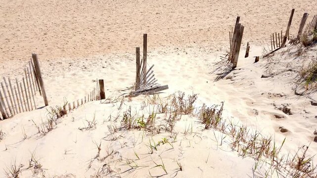 A slow pan up over the bright sand to reveal a clear bright blue sea