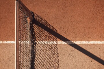 Overhead View of Tennis Court Net and Lines, Clay Surface, Shadow Play.