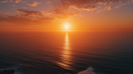 Obraz premium The ocean water reflects the sunlight as the sunset colors the sky and ocean. Ocean waves gently move under the setting sun, creating a peaceful sunset scene.