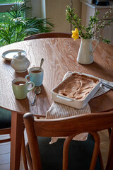 Traditional apple pie on a wooden plate on a light culinary background. Charlotte pie on a platter in closeup. Delicious homemade cakes on the kitchen table