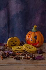 Top view of Halloween cookies with pumpkin with eyes, leaves and nuts, vertically with copy space