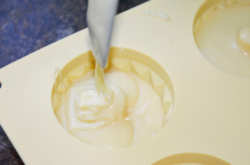 pouring liquid muffin batter into silicone baking mold. making dessert at home. tasty food for kids and adults
