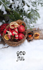 God Jul! greeting card. wicker basket with straw Yule Goat toy, apples and witch cauldron in snowy...
