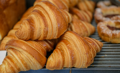 Freshly baked croissants on display in a bakery, golden brown and flaky.