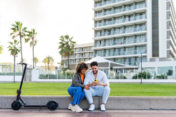 Young couple using smartphone near electric scooter