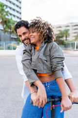 Fototapeta premium Happy couple embracing, riding electric scooter in city