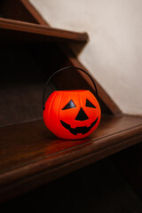 Pumpkin lantern on wooden stairs in the house. Concept of decorations and preparation for Halloween