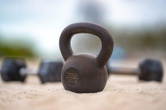 Kettlebell strength workout. Kettlebell training outdoors. Kettlebell exercise in the park. Kettlebell fitness background. Kettlebells heavy lifting. - Powered by Adobe