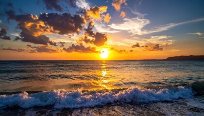 Obraz premium Radiant sunset illuminates the ocean, casting golden hues across the water as waves crash against the shore; the sky is filled with clouds painted in shades of orange, yellow, and blue, creating a...