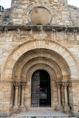 Fototapeta premium The main portal and oculus window of the 12th-century Romanesque church of Santa Maria de Porqueres. Catalonia, Spain.