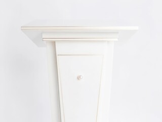 A close-up view of a white, ornate fireplace mantel against a plain wall.