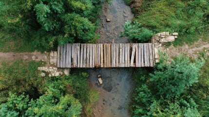 Construction Slowdown Design. Wooden footbridge crosses a forest stream surrounded by dense green trees.