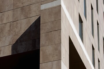 Modern building corner with textured facade and shadow